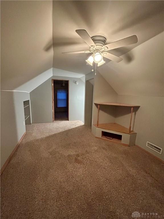 additional living space featuring ceiling fan, lofted ceiling, and carpet flooring