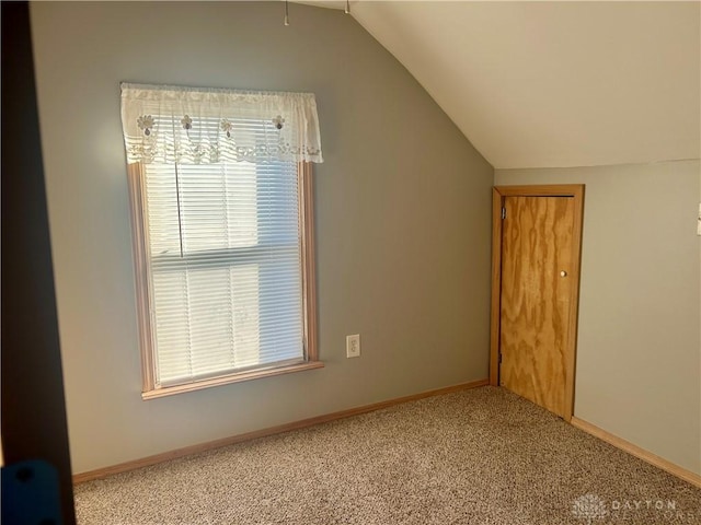 additional living space featuring light carpet and vaulted ceiling