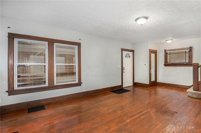 spare room featuring hardwood / wood-style flooring and a textured ceiling