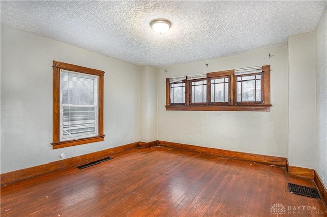 spare room with wood-type flooring and a textured ceiling