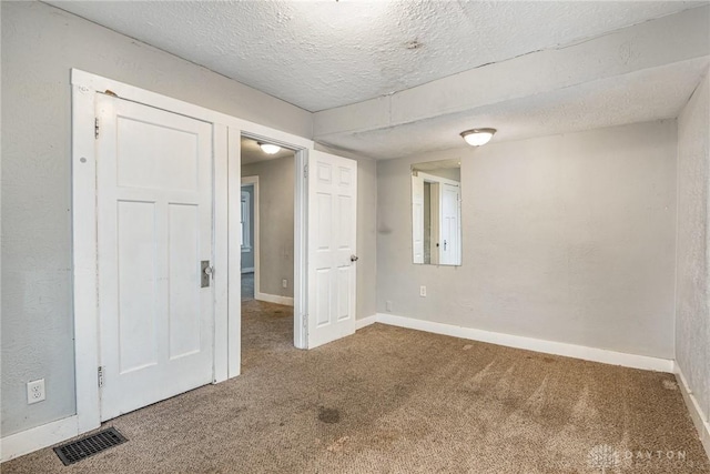 unfurnished room featuring carpet floors and a textured ceiling