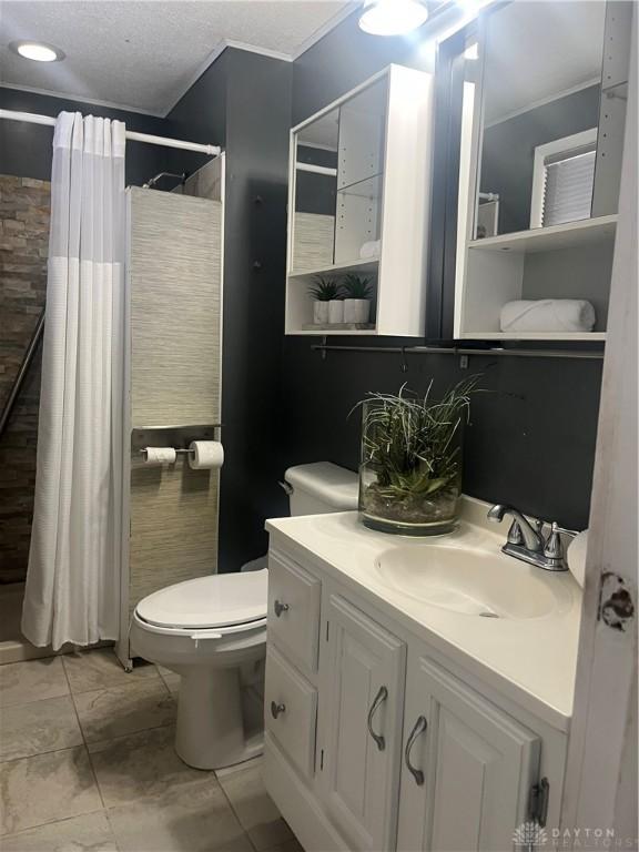 bathroom with a shower with curtain, vanity, toilet, and a textured ceiling