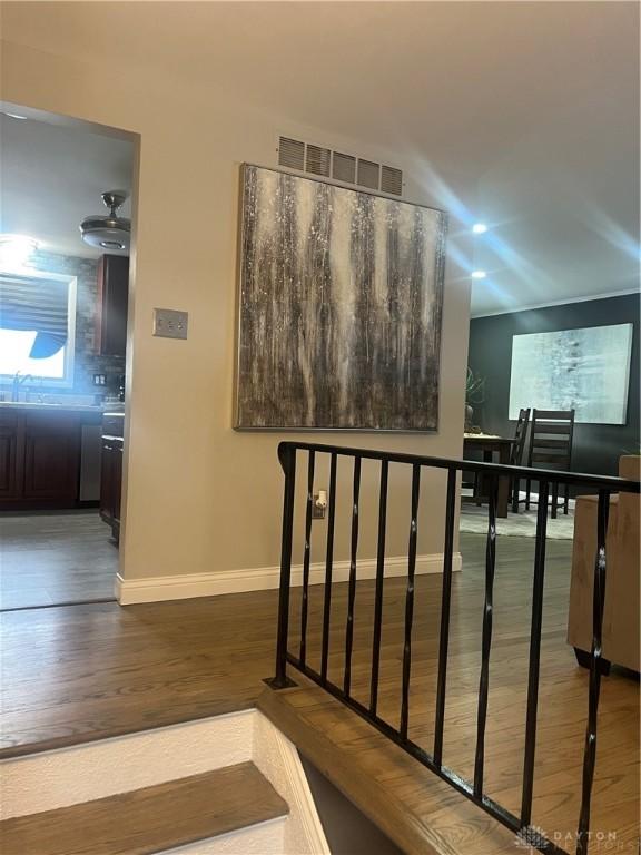 stairway with visible vents, baseboards, and wood finished floors