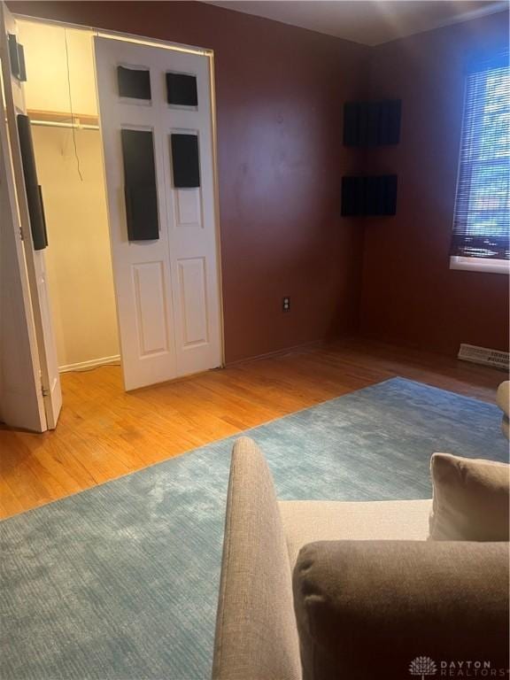 interior space with a walk in closet, wood-type flooring, and a closet