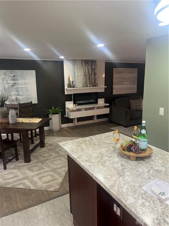 interior space featuring light stone countertops, dark brown cabinetry, and light wood-style flooring