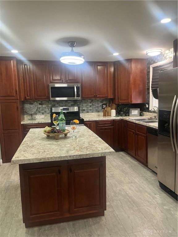 kitchen with stainless steel appliances, a center island, sink, and backsplash