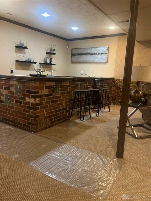 bar with crown molding and carpet floors