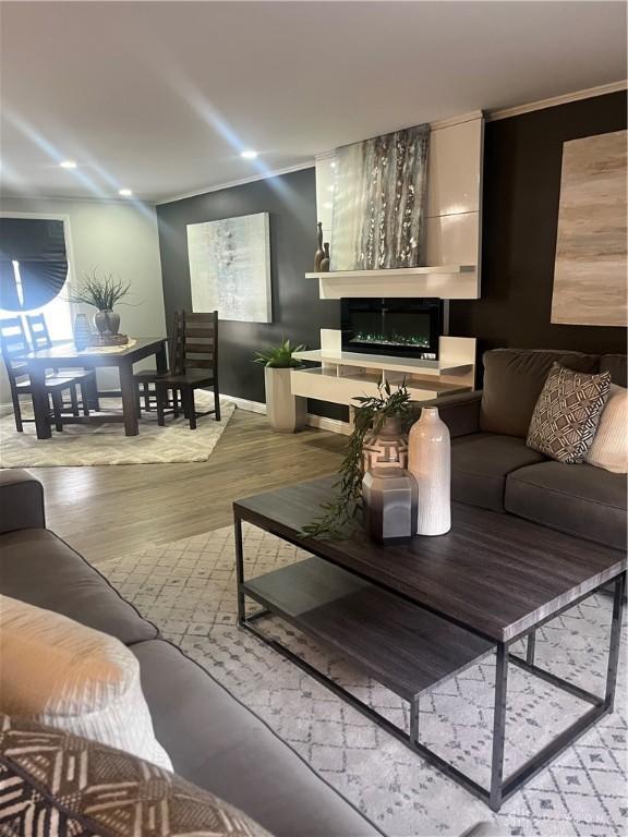 living room featuring recessed lighting, a fireplace, and light wood finished floors