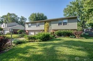 split foyer home featuring a garage and a front lawn