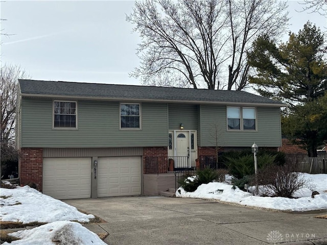 split foyer home featuring concrete driveway, brick siding, and an attached garage