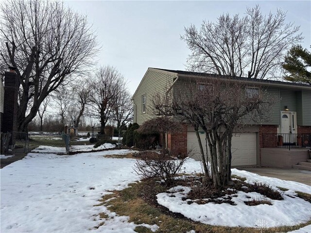 snow covered property with a garage