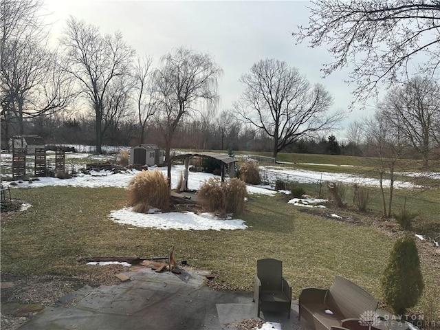 snowy yard with a storage shed