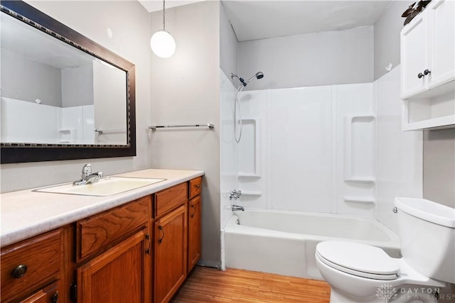 full bath with vanity, shower / tub combination, wood finished floors, and toilet