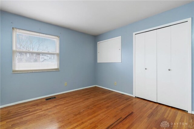 unfurnished bedroom with wood-type flooring and a closet