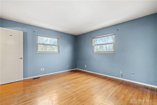 empty room with light hardwood / wood-style flooring and plenty of natural light