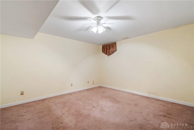 empty room featuring ceiling fan and carpet