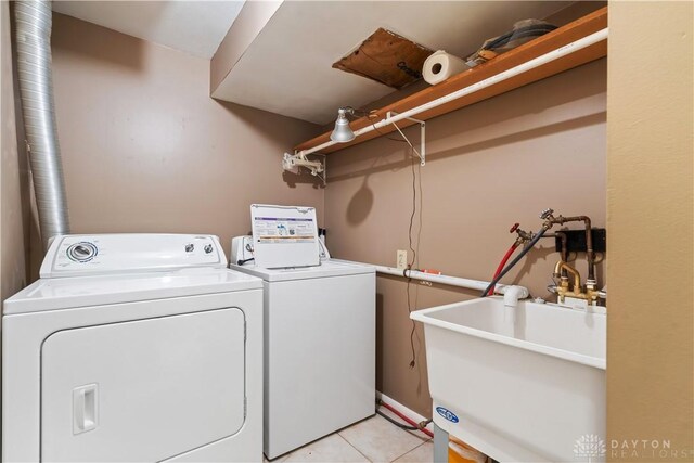 laundry room featuring separate washer and dryer, sink, and light tile patterned floors