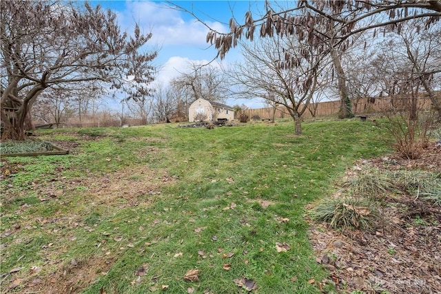 view of yard featuring an outbuilding and fence