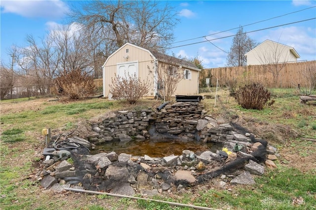 view of yard with an outbuilding, a storage shed, and fence