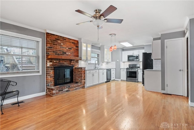 kitchen with crown molding, black appliances, hanging light fixtures, backsplash, and white cabinets