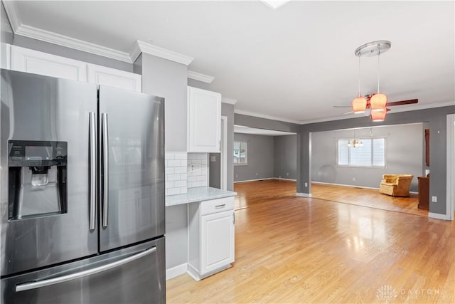 kitchen with crown molding, light wood finished floors, backsplash, white cabinets, and stainless steel fridge with ice dispenser