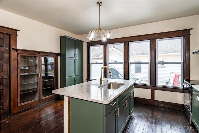 kitchen with pendant lighting, sink, a chandelier, dark hardwood / wood-style flooring, and a center island with sink