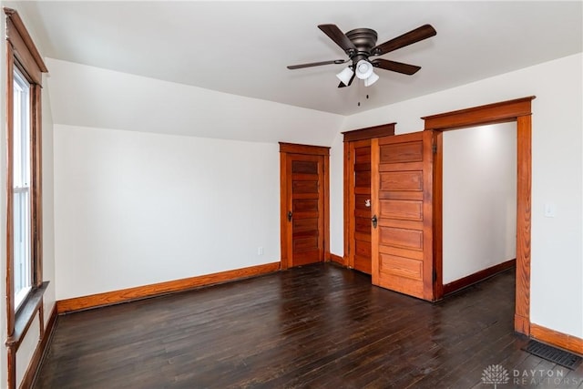 unfurnished bedroom featuring lofted ceiling, dark hardwood / wood-style flooring, a closet, and ceiling fan