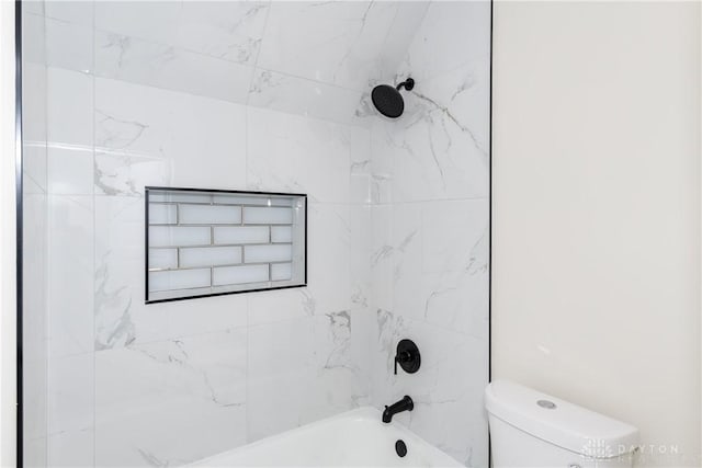 bathroom featuring toilet and tiled shower / bath