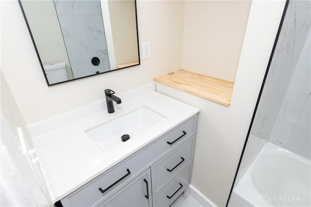 full bathroom featuring tiled shower / bath, vanity, and toilet