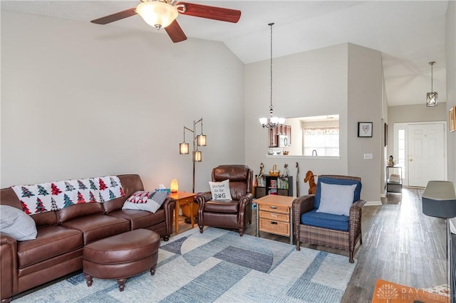 living room with high vaulted ceiling, wood-type flooring, and ceiling fan with notable chandelier