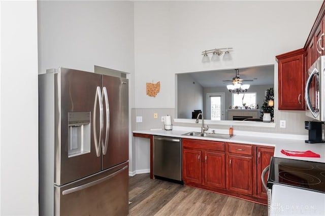 kitchen featuring wood-type flooring, appliances with stainless steel finishes, sink, and ceiling fan