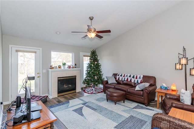 living room with a fireplace, vaulted ceiling, dark hardwood / wood-style floors, and ceiling fan