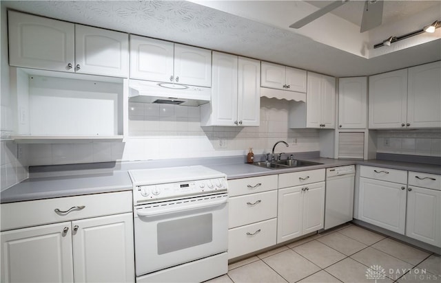 kitchen with light tile patterned flooring, sink, white cabinetry, white appliances, and decorative backsplash