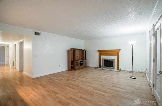 unfurnished living room featuring ornamental molding, a textured ceiling, and light hardwood / wood-style flooring