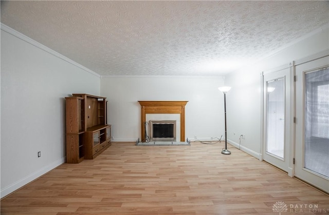 unfurnished living room featuring crown molding, a healthy amount of sunlight, a textured ceiling, and light wood-type flooring