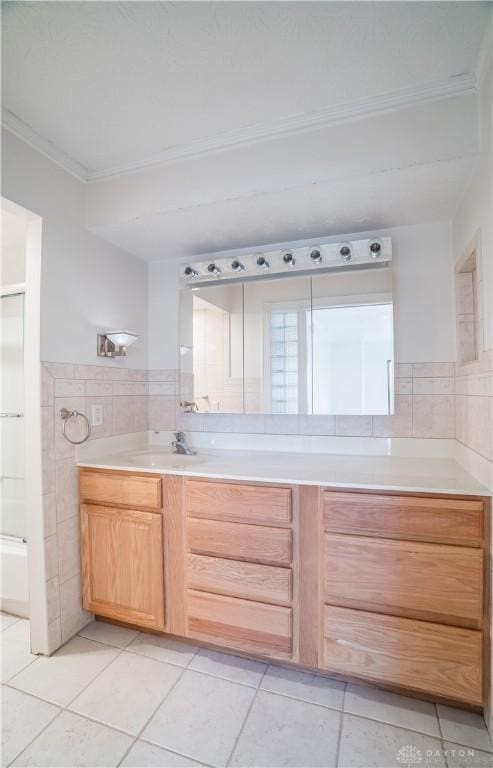 bathroom with ornamental molding, vanity, tile patterned flooring, and tile walls