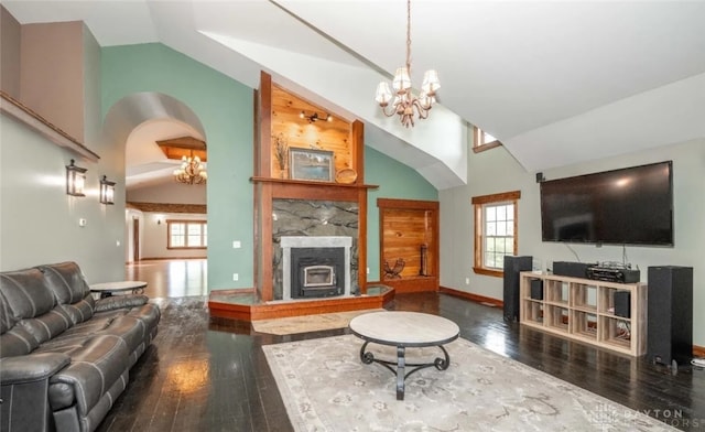 living room featuring an inviting chandelier, a fireplace, and dark wood-type flooring