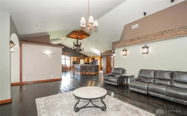 living room featuring an inviting chandelier, lofted ceiling, and dark hardwood / wood-style floors