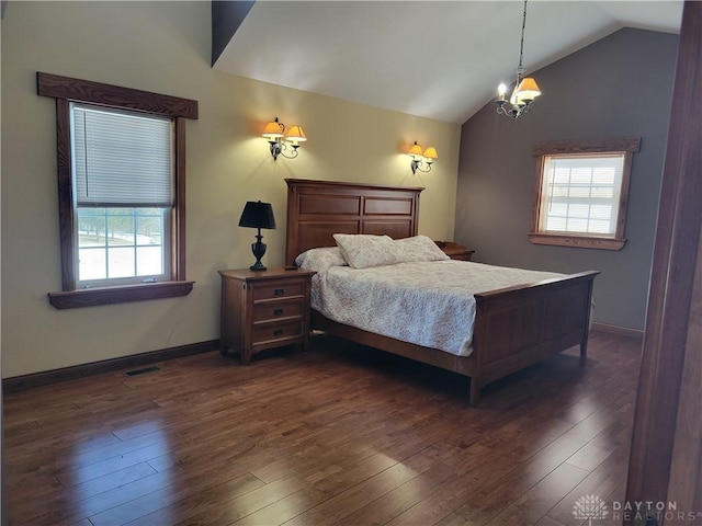 bedroom featuring multiple windows, dark hardwood / wood-style flooring, a chandelier, and vaulted ceiling