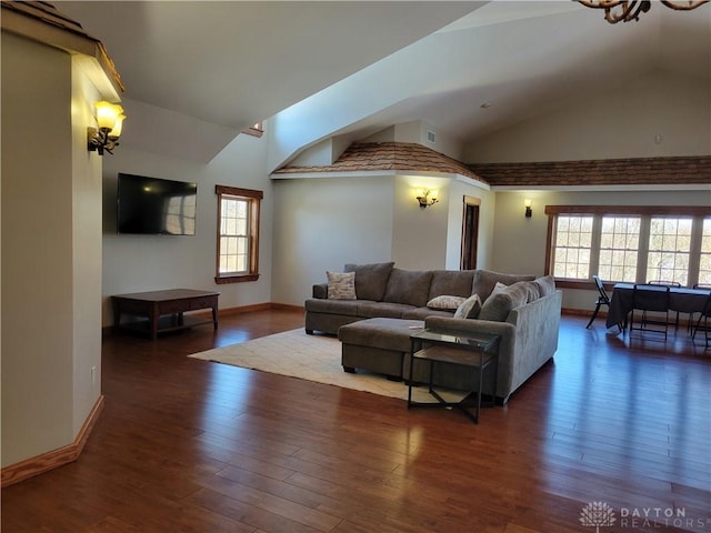 living room featuring dark hardwood / wood-style floors, a wealth of natural light, and high vaulted ceiling
