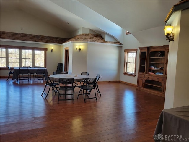 dining space with dark wood-type flooring and high vaulted ceiling