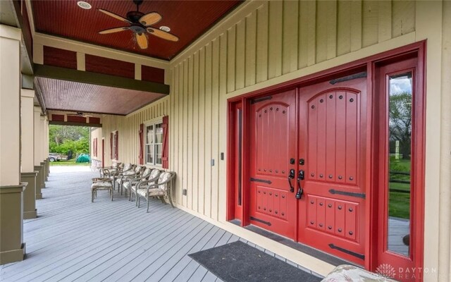 view of exterior entry featuring ceiling fan and a porch