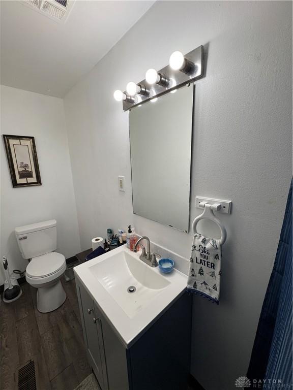 bathroom with vanity, hardwood / wood-style floors, and toilet