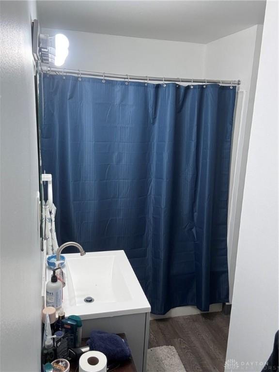 bathroom with a shower with shower curtain, sink, and hardwood / wood-style floors