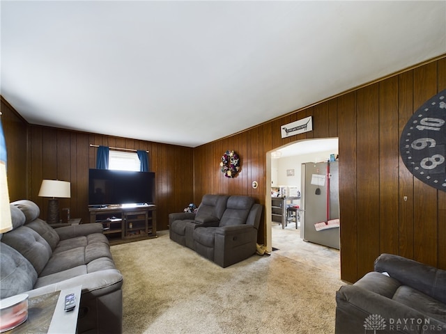 carpeted living room featuring wood walls