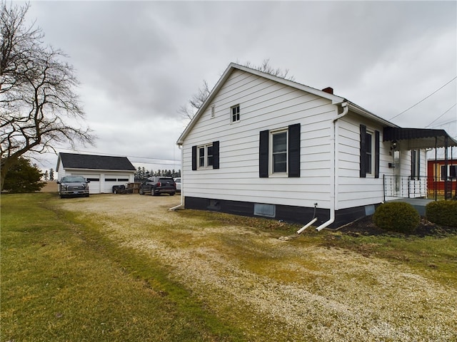 view of property exterior with a garage, a yard, and an outdoor structure