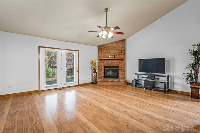 unfurnished living room with vaulted ceiling, a brick fireplace, wood-type flooring, and ceiling fan