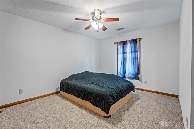 bedroom featuring ceiling fan, carpet, and a textured ceiling