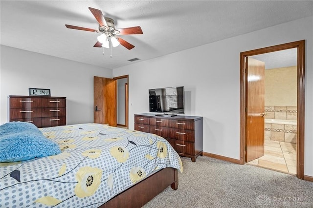 bedroom with ceiling fan, light colored carpet, and connected bathroom