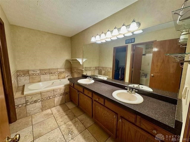 bathroom with vanity, plus walk in shower, tile patterned flooring, and a textured ceiling